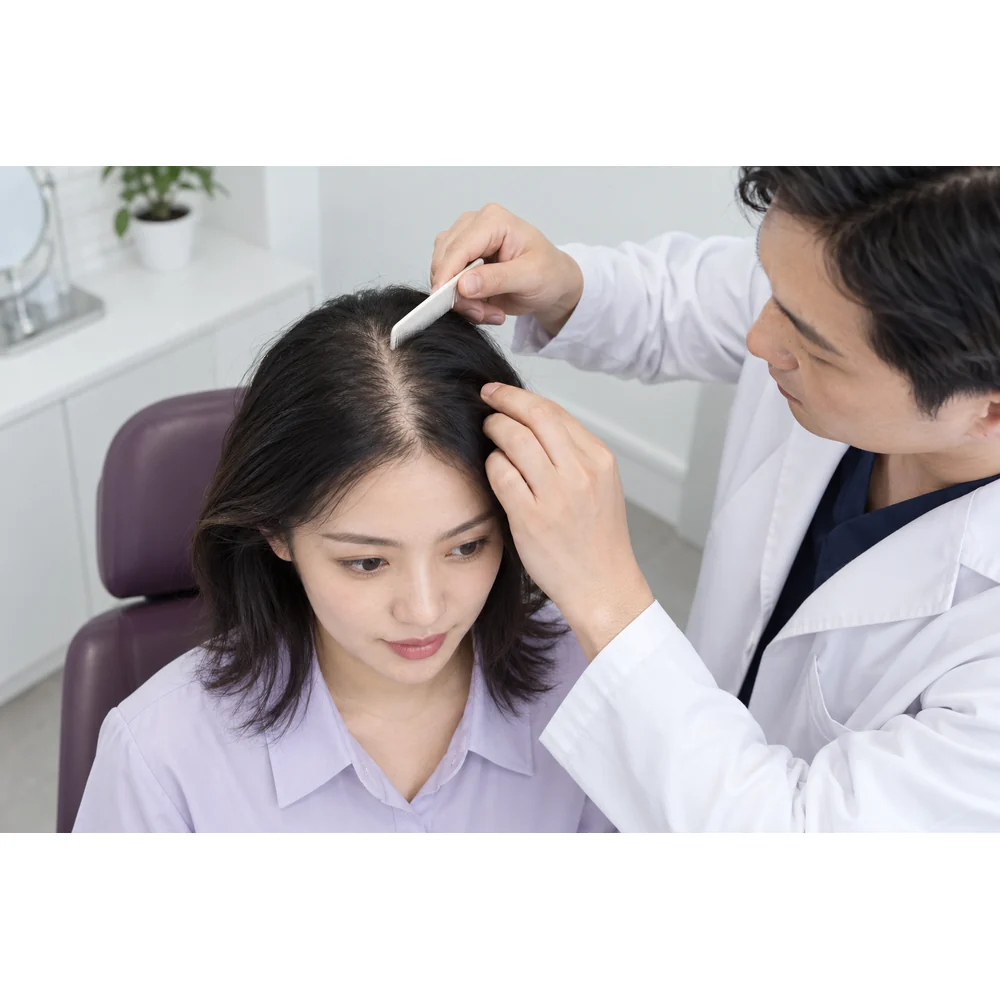 Imej rujukan wanita dewasa berbincang dengan klinisian tentang corak rambut menipis dan keadaan kulit kepala yang direkodkan